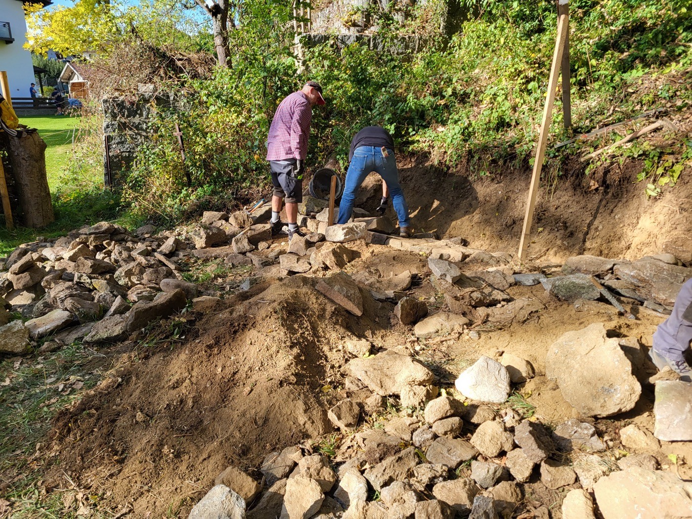 Teilnehmer setzen Bau von Stützmauer fort (2/3)