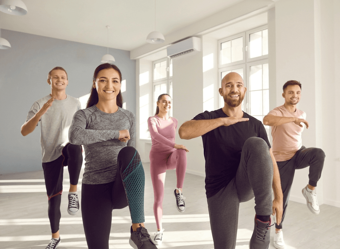 Group fitness class with people of different body types exercising together indoors