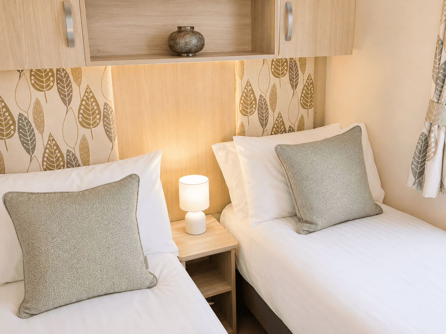 1 Harbour Reach the twin room, both beds in a warm lighting on a sunny day