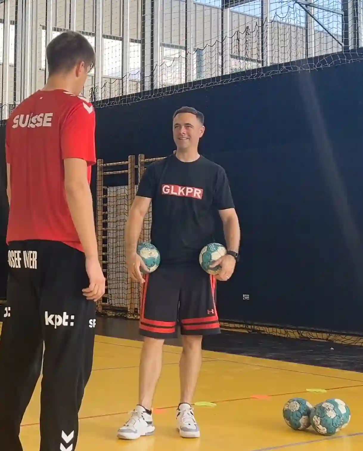 Close-up of a dark green leaf showing its textured surface and central vein against a muted background.