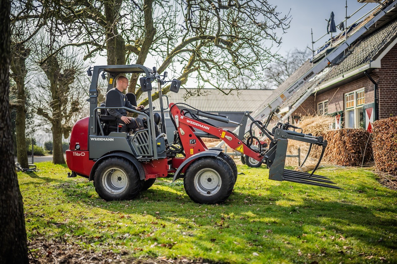 Rietdekker van Rietdekkersbedrijf van Dijk bezig met het verplaatsen van riet