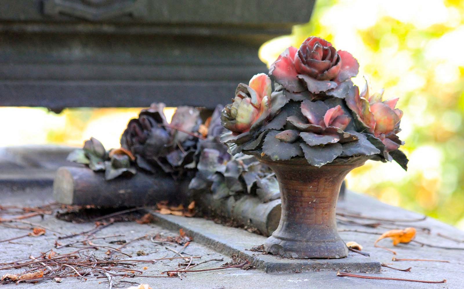 Steingrav smykket med blomsterskulptur på Père Lachaise kirkegård.