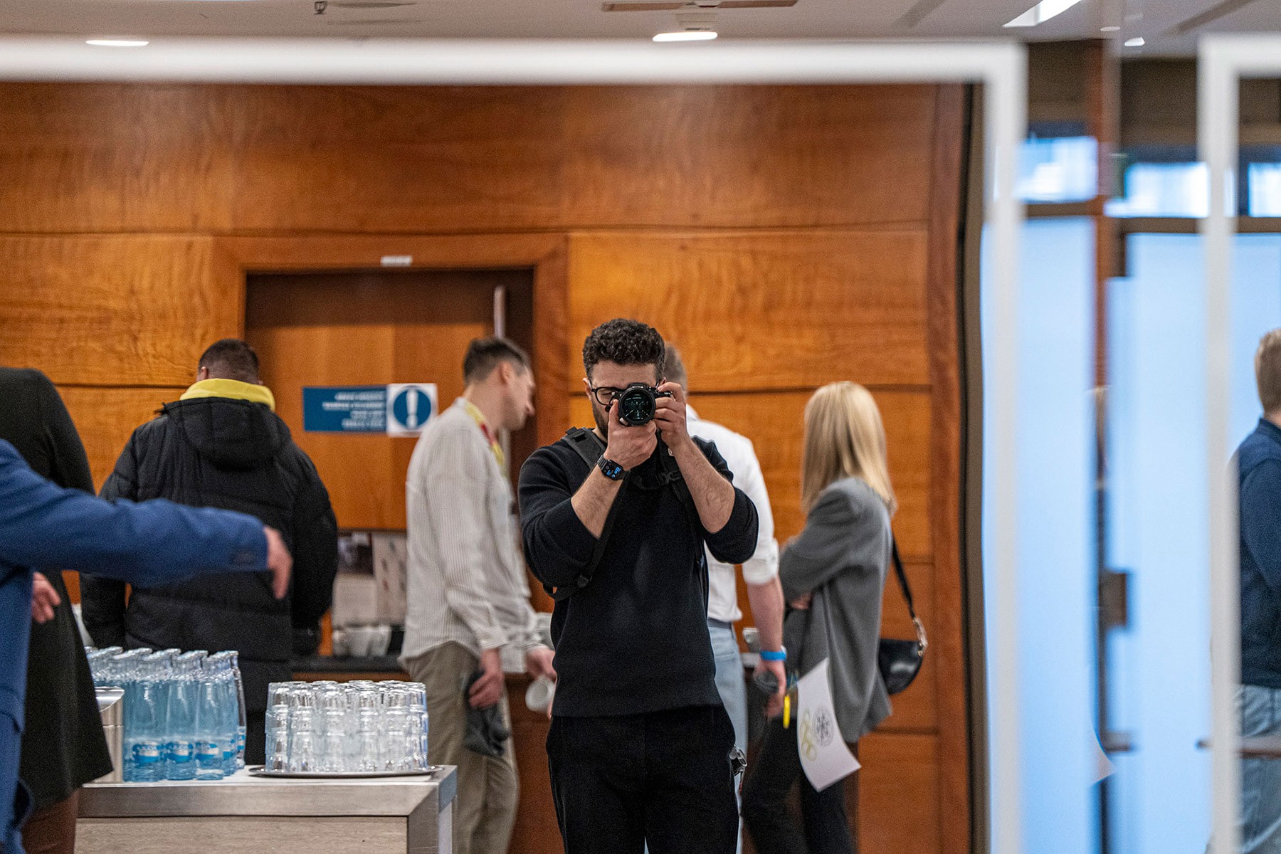 Conference photographer capturing a self-portrait during corporate event coverage at CWS Workwear conference venue.