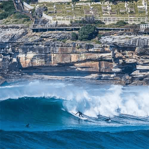 Surfer riding a wave at a Sydney beach – surfboard rental in sydney.