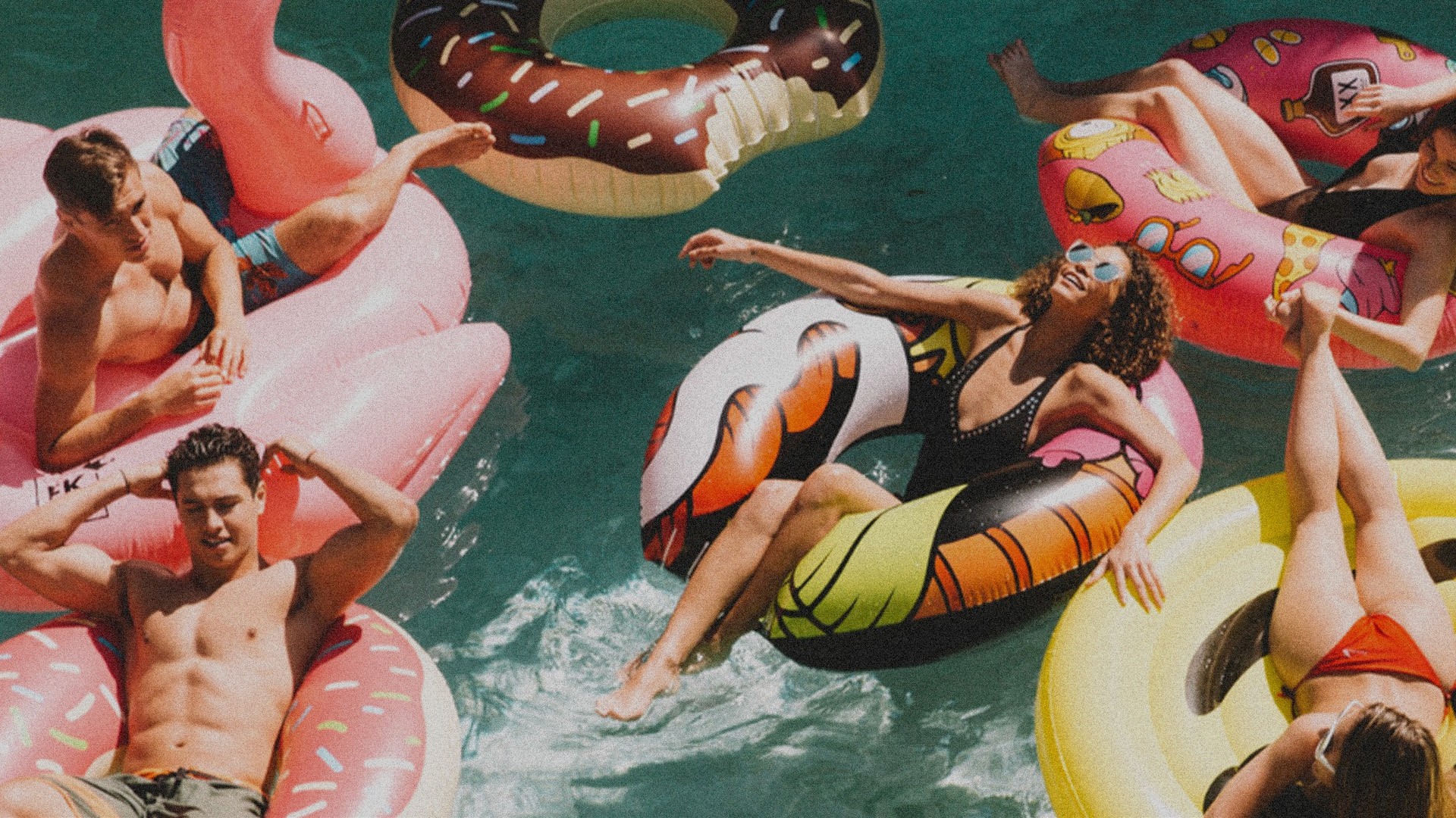 A group of people in water all in different inflatables.
