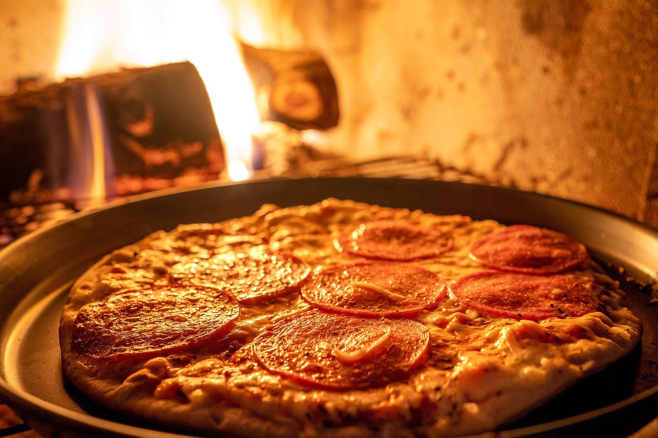 Pepperoni pizza baking in a wood-fired oven