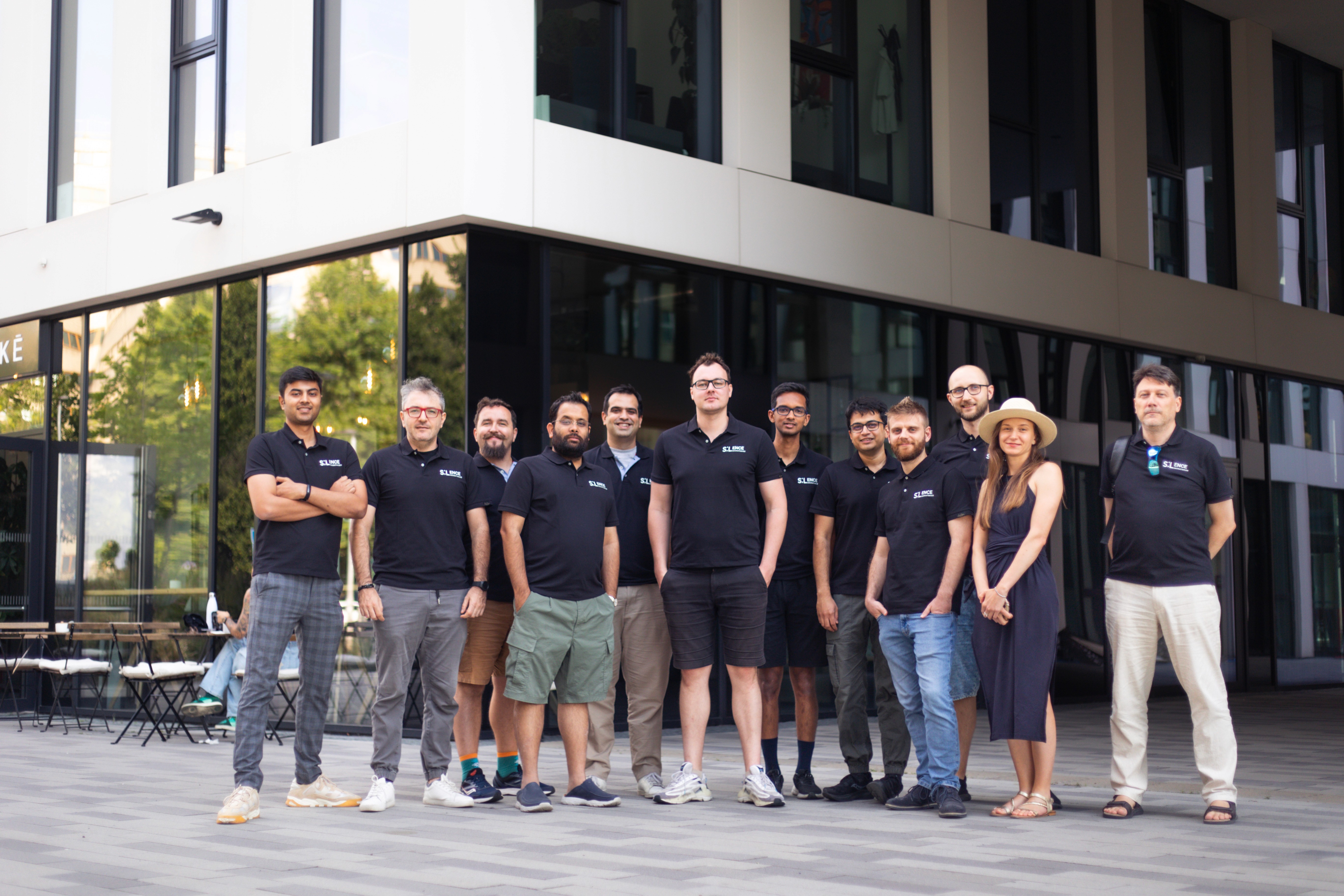 Silhouette of a researcher examining a slide under a microscope with a blue background.