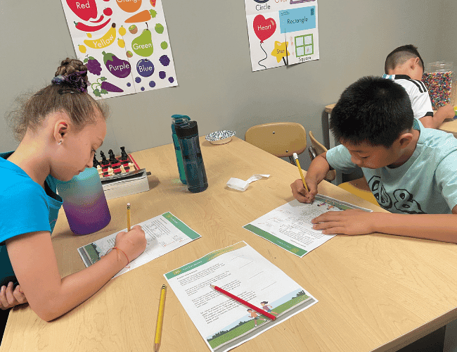 A boy and a girl doing math problem solving at a table