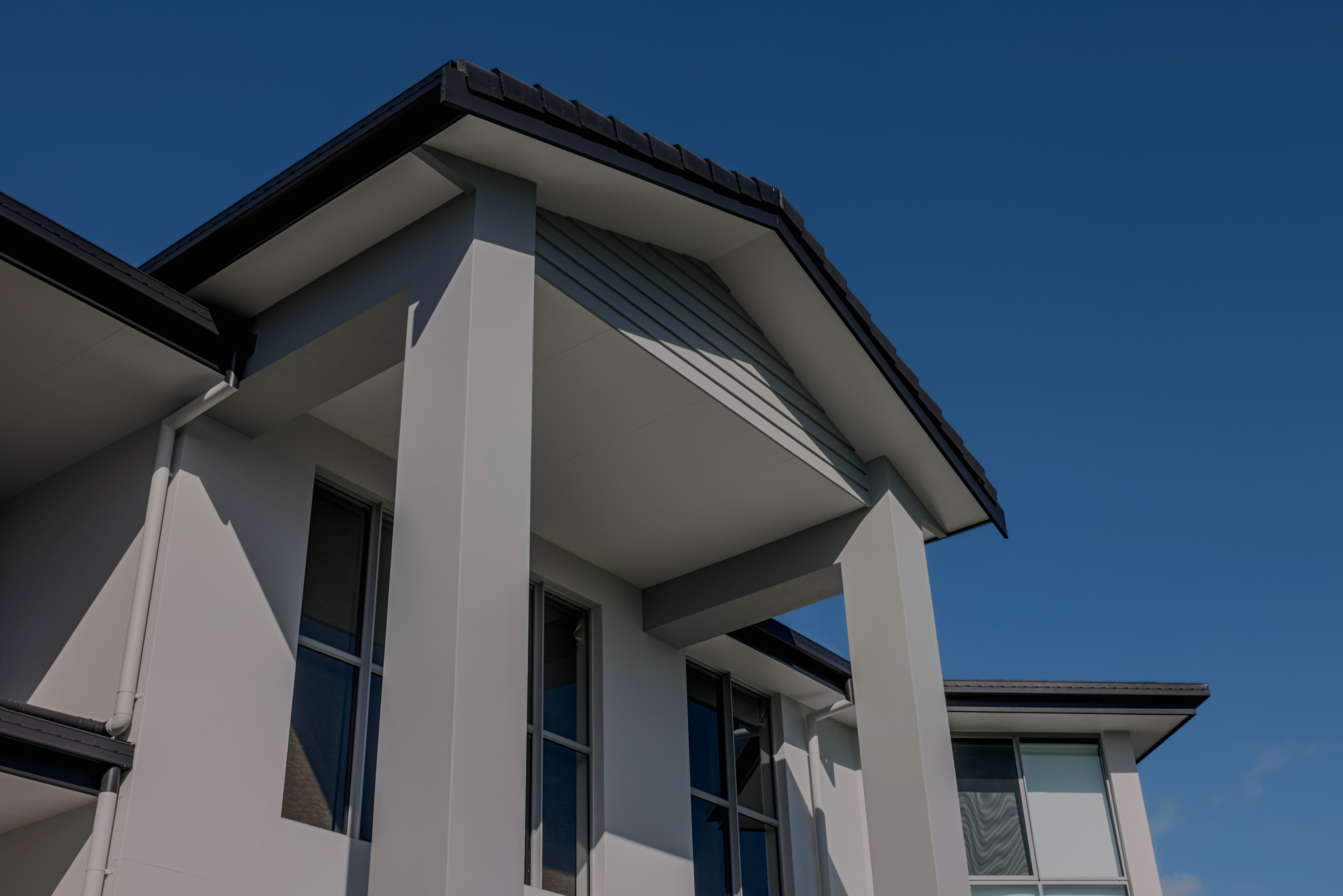 Two-storey white coastal home with freshly painted eaves and balcony — Gold Coast exterior painting