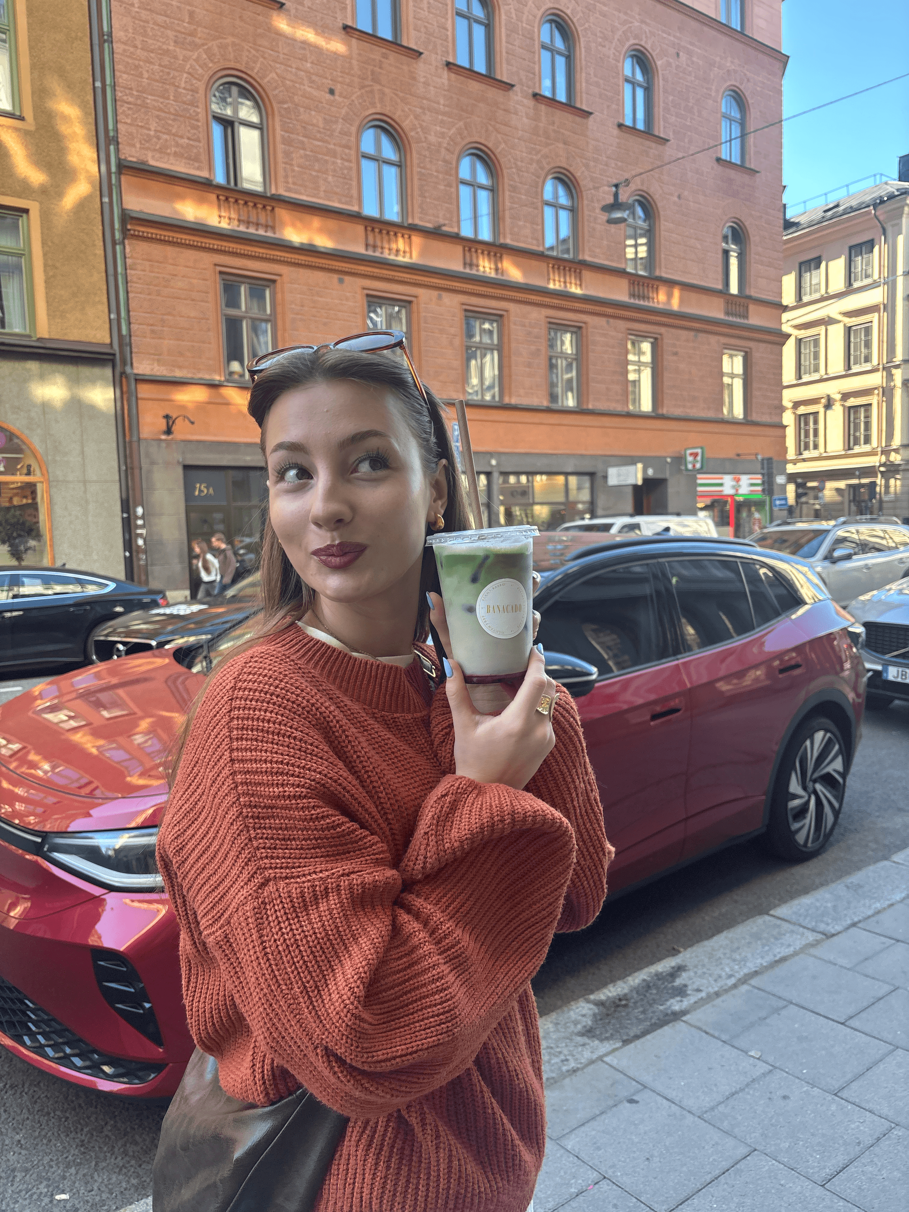 A close-up of a hand wearing multiple decorative rings against a blue background.