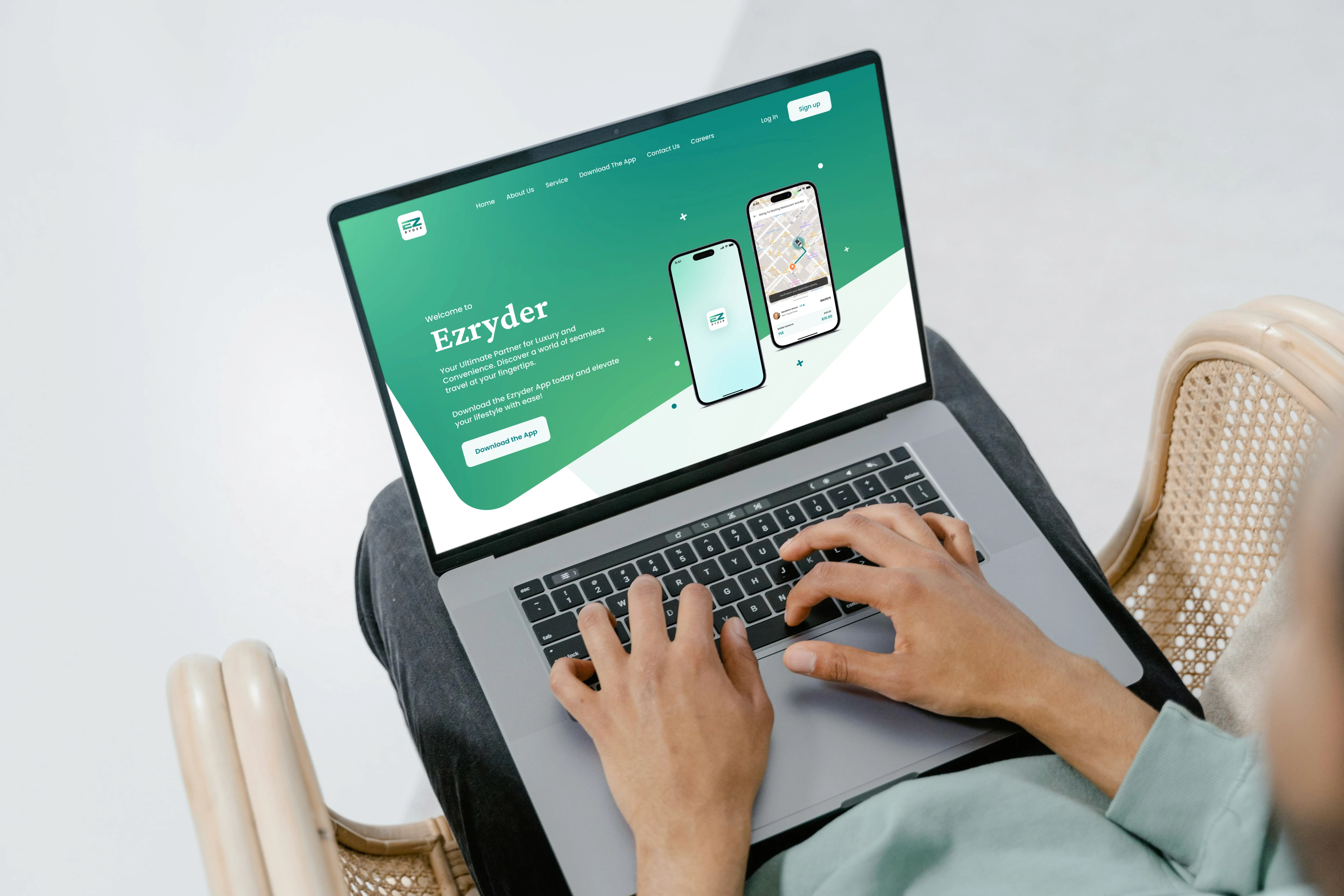 User typing on a laptop displaying the Ezryder ride-hailing mobile app landing page.