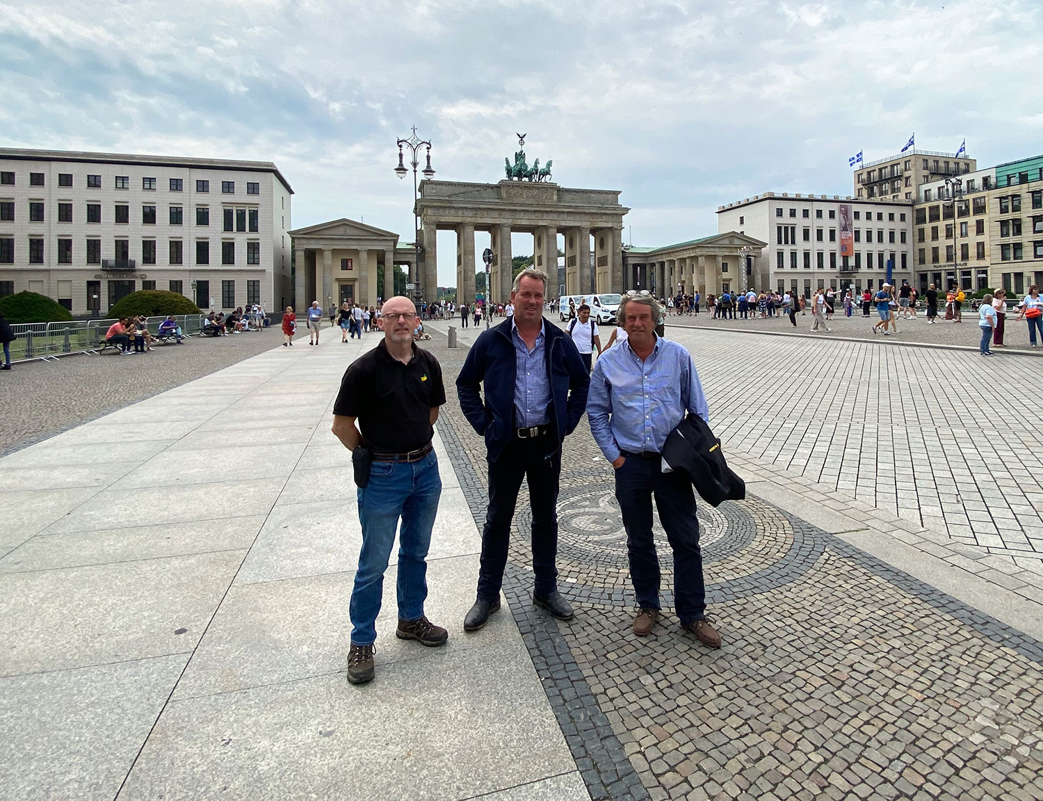 Three Fen Peas team members standing in the street at the Brandenburg Gate, Germany