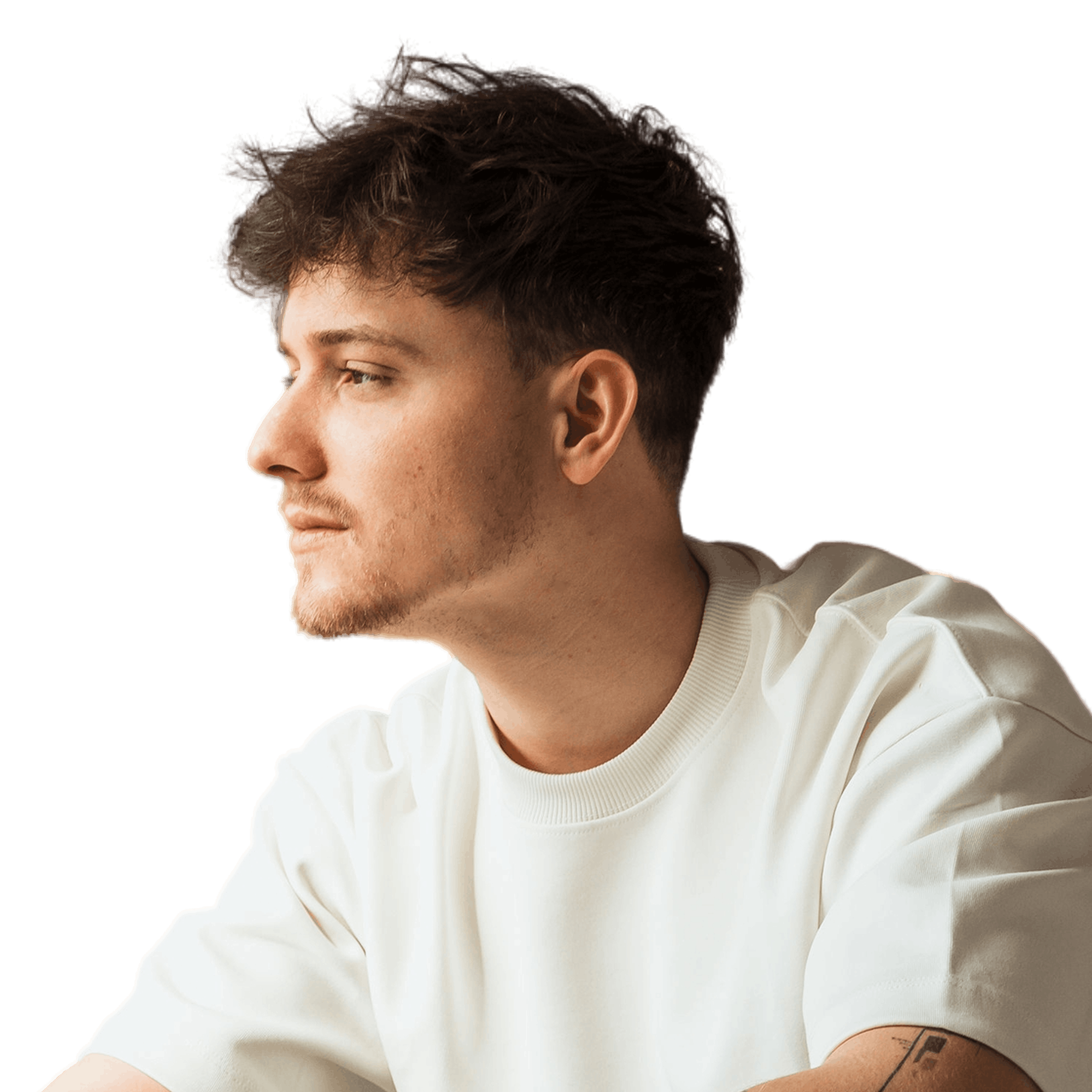 Young man working on laptop, focused expression. Indoor workspace.