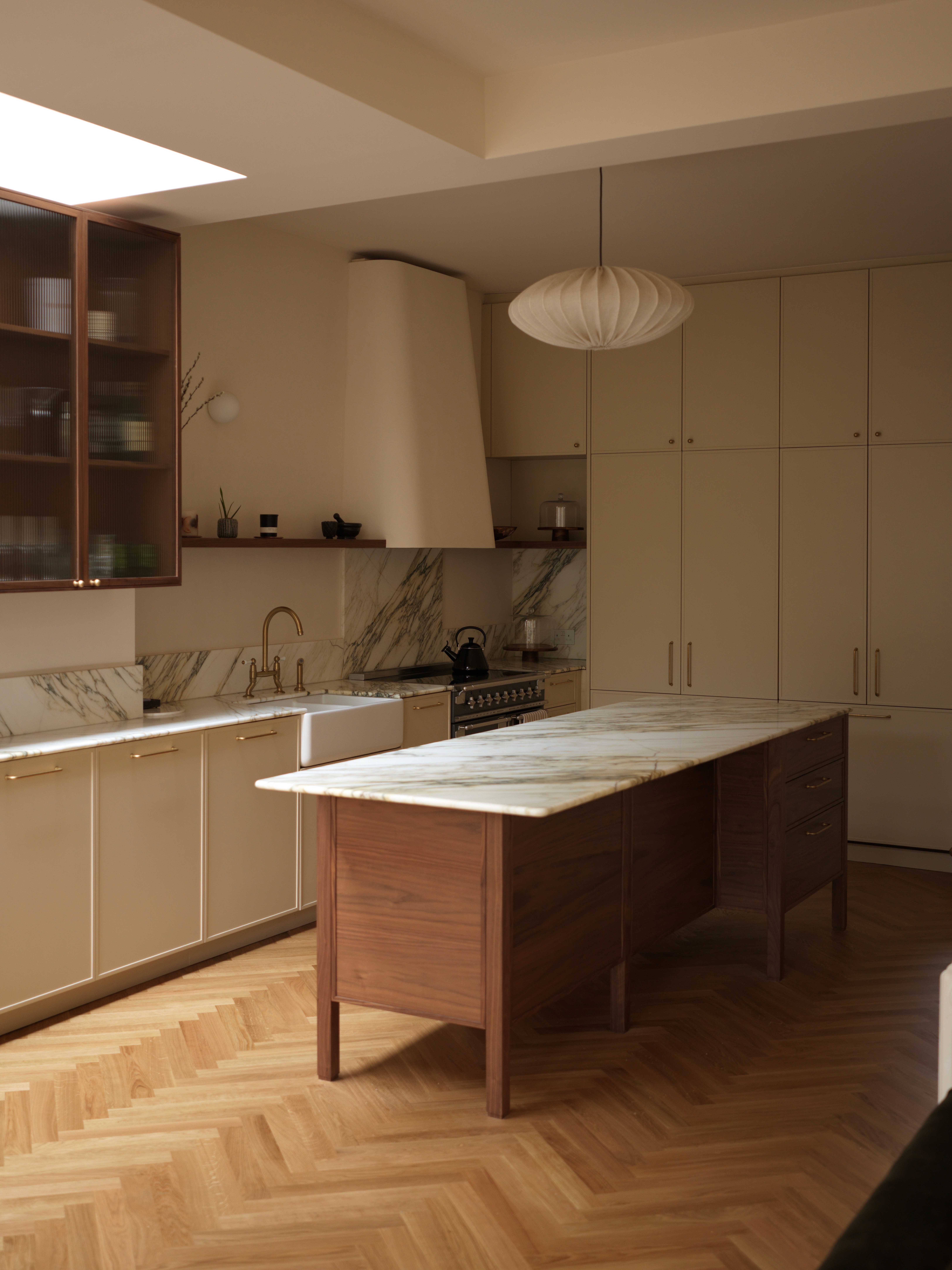 Contemporary kitchen with pale cabinetry, timber flooring, and central island