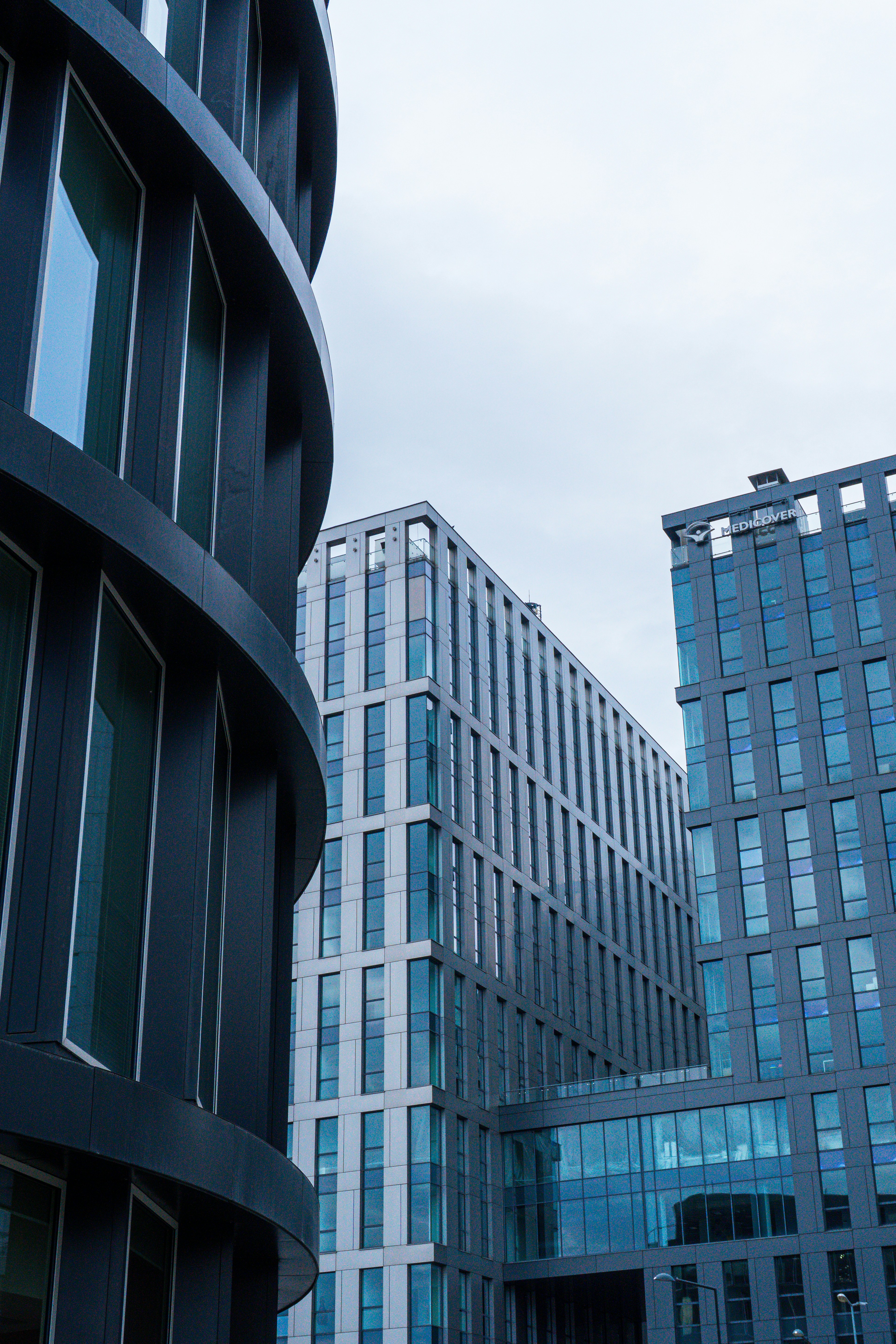 Modern office buildings with geometric facades under a cloudy sky