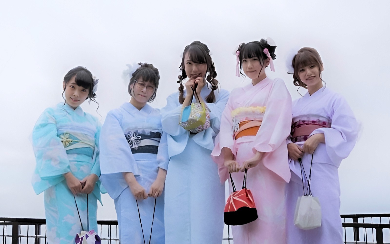 Tourist in traditional kimono walking through Asakusa, Tokyo, with Senso-ji Temple in the background.