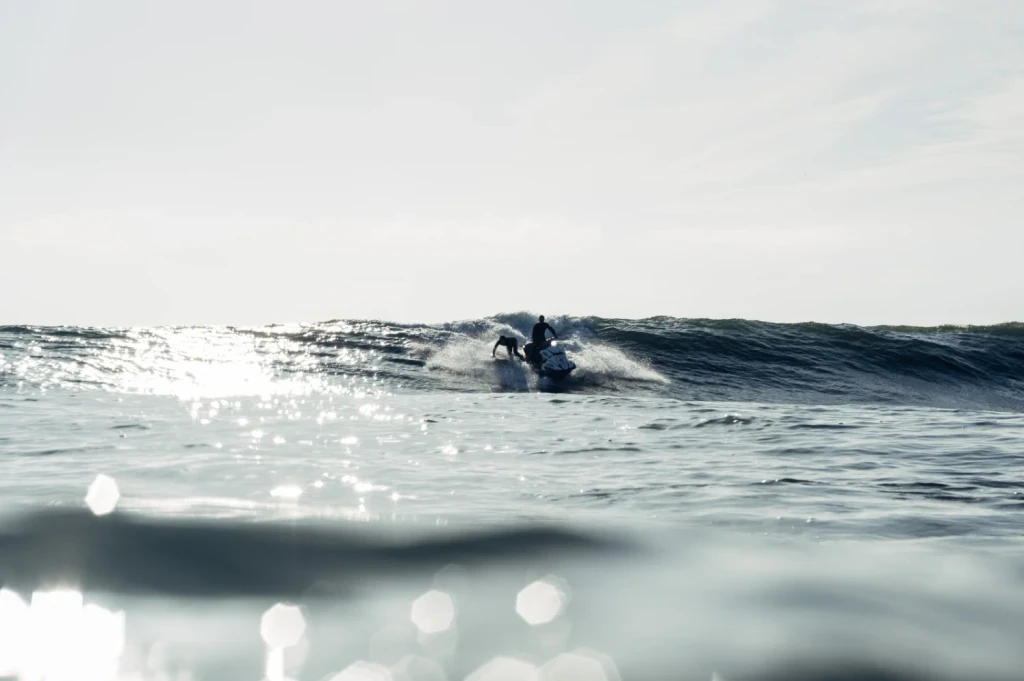 A man swimming next to his surfboard in the ocean.
