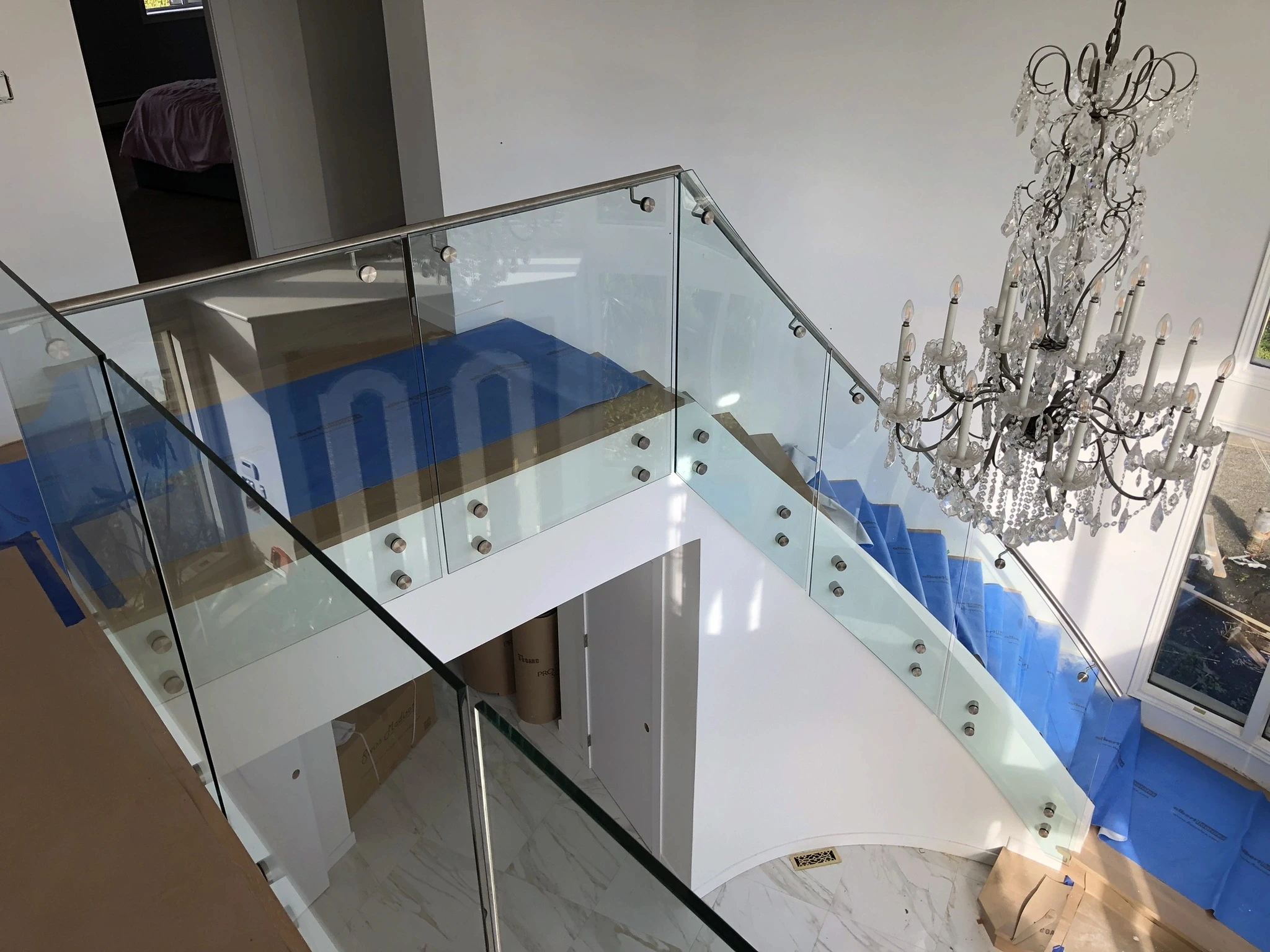 Standoff glass railing with black hardware along a raised interior platform