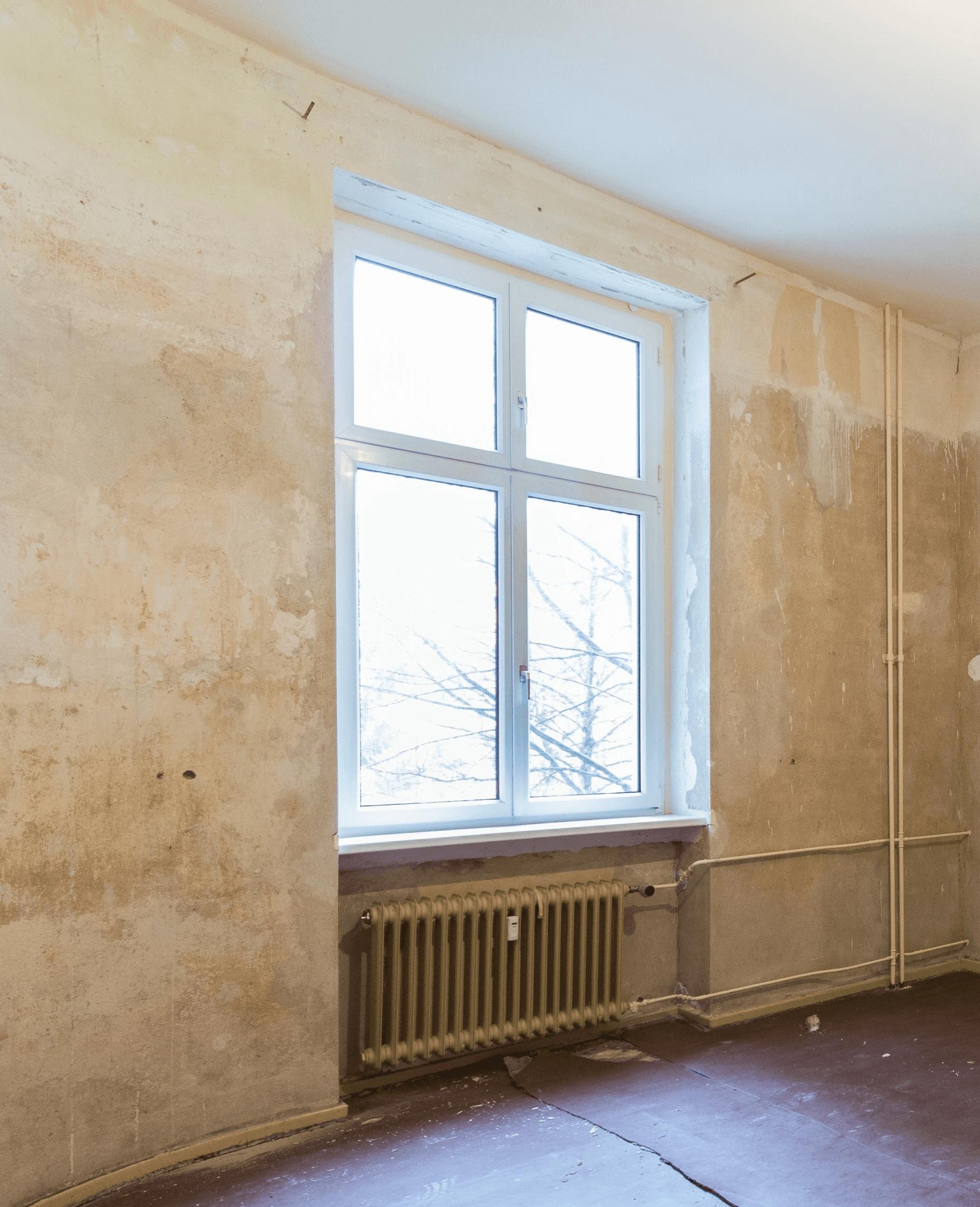 Smiling young man with short hair poses against a dark background, wearing a green button-up shirt.