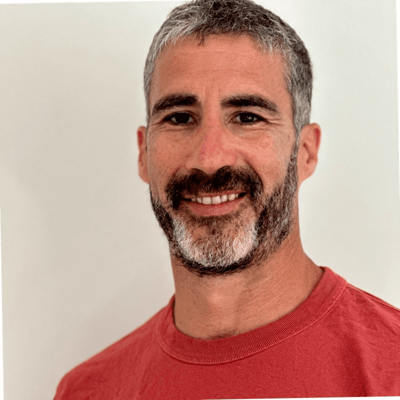 a man with a goatee smiles at the camera