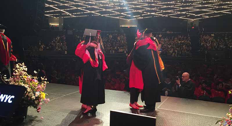 students hugging professors during graduation