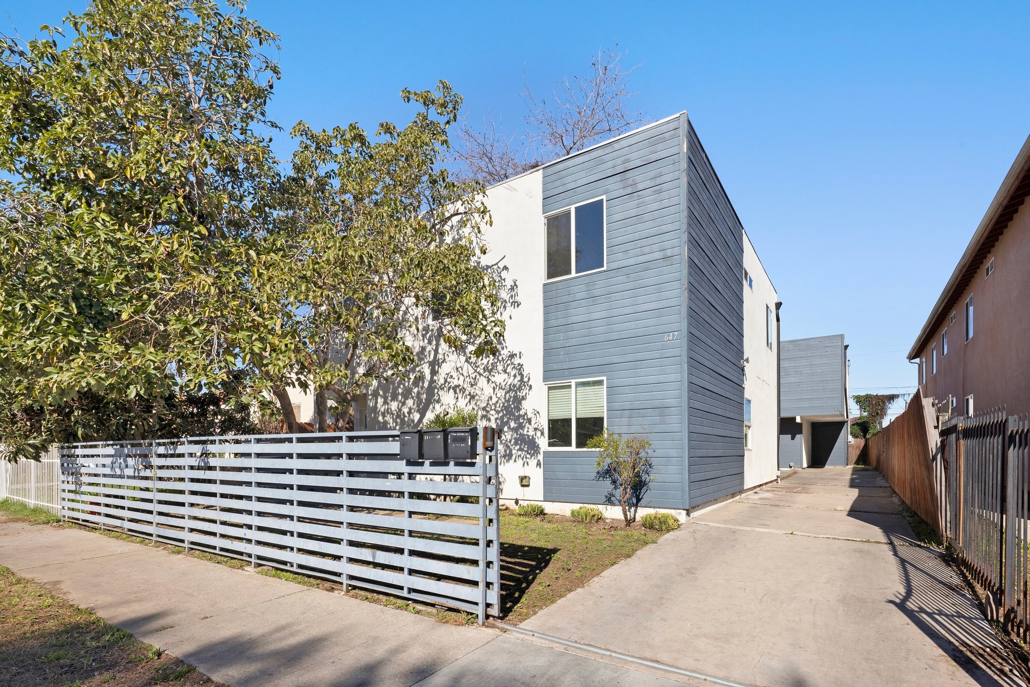 Wide exterior view of triplex buildings and shared parking courtyard at 645 west 97th street.