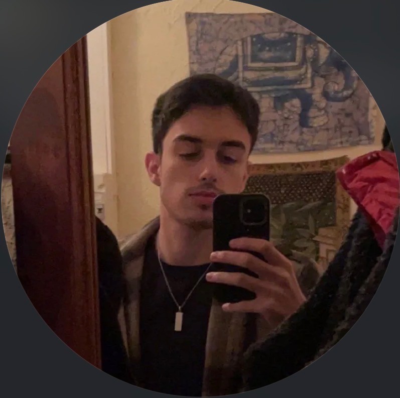 a man with a goatee smiles at the camera