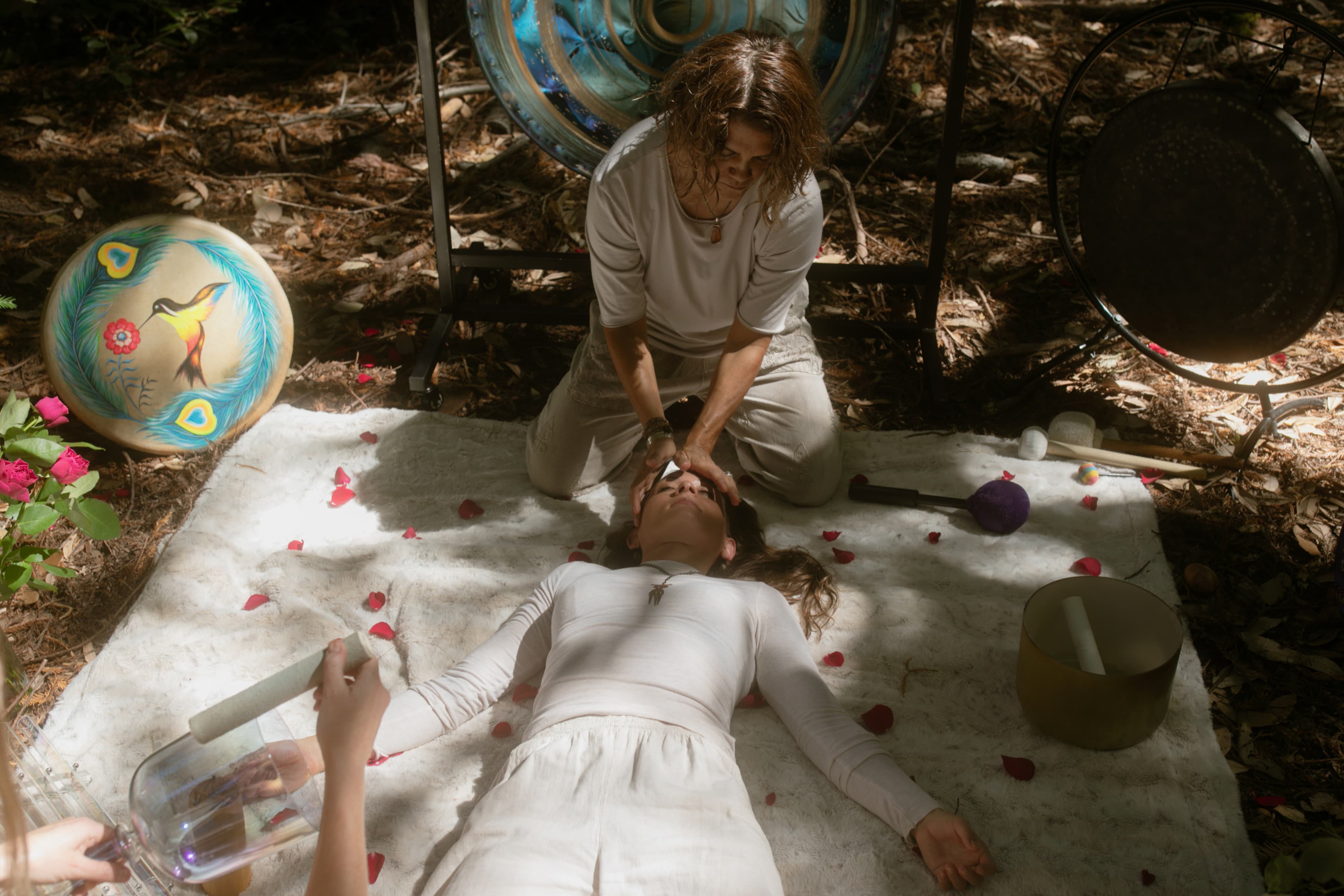 Guide performing bodywork during a solo plant medicine ceremony outdoors