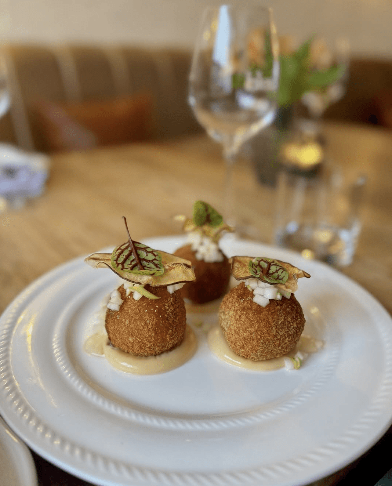 Gourmet dish plated in a black bowl on a dark wooden table.