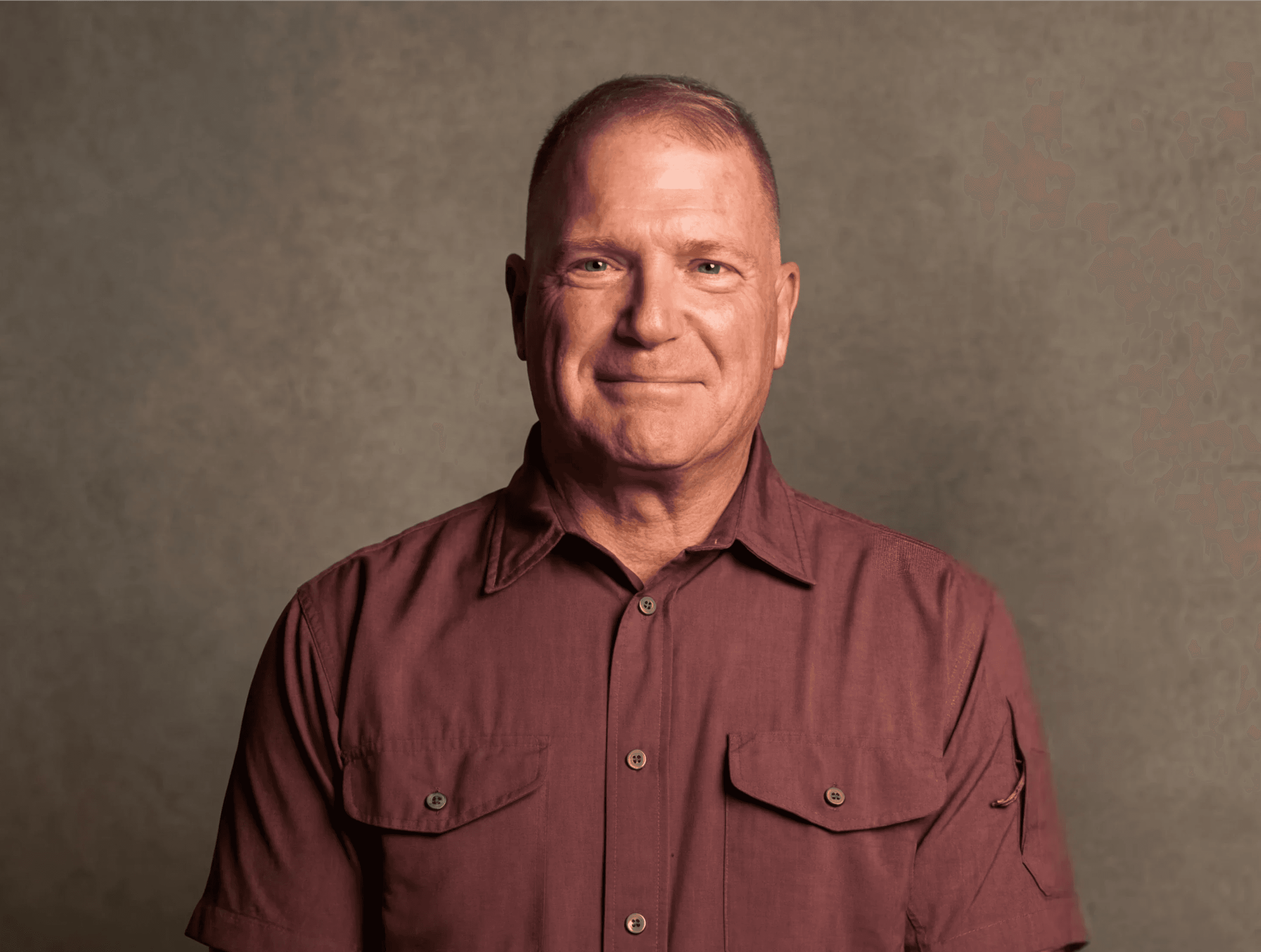 Man in black hoodie and sunglasses holding finger to lips.