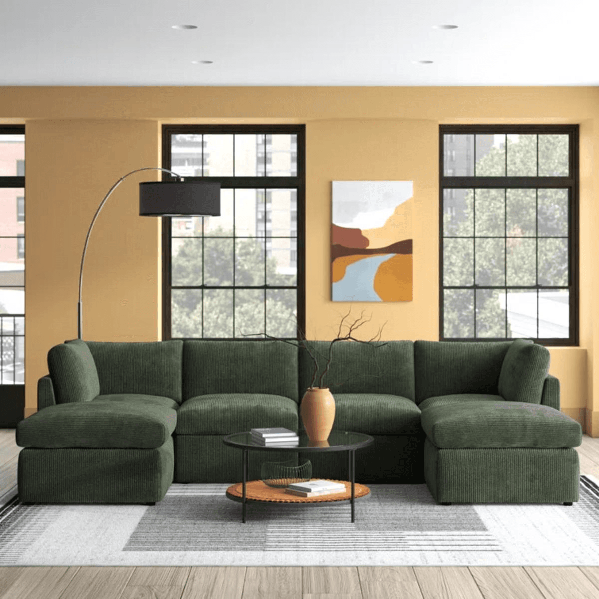 Dark green Wade Logan reversible modular corner sectional sofa in a room with large windows and yellow walls.