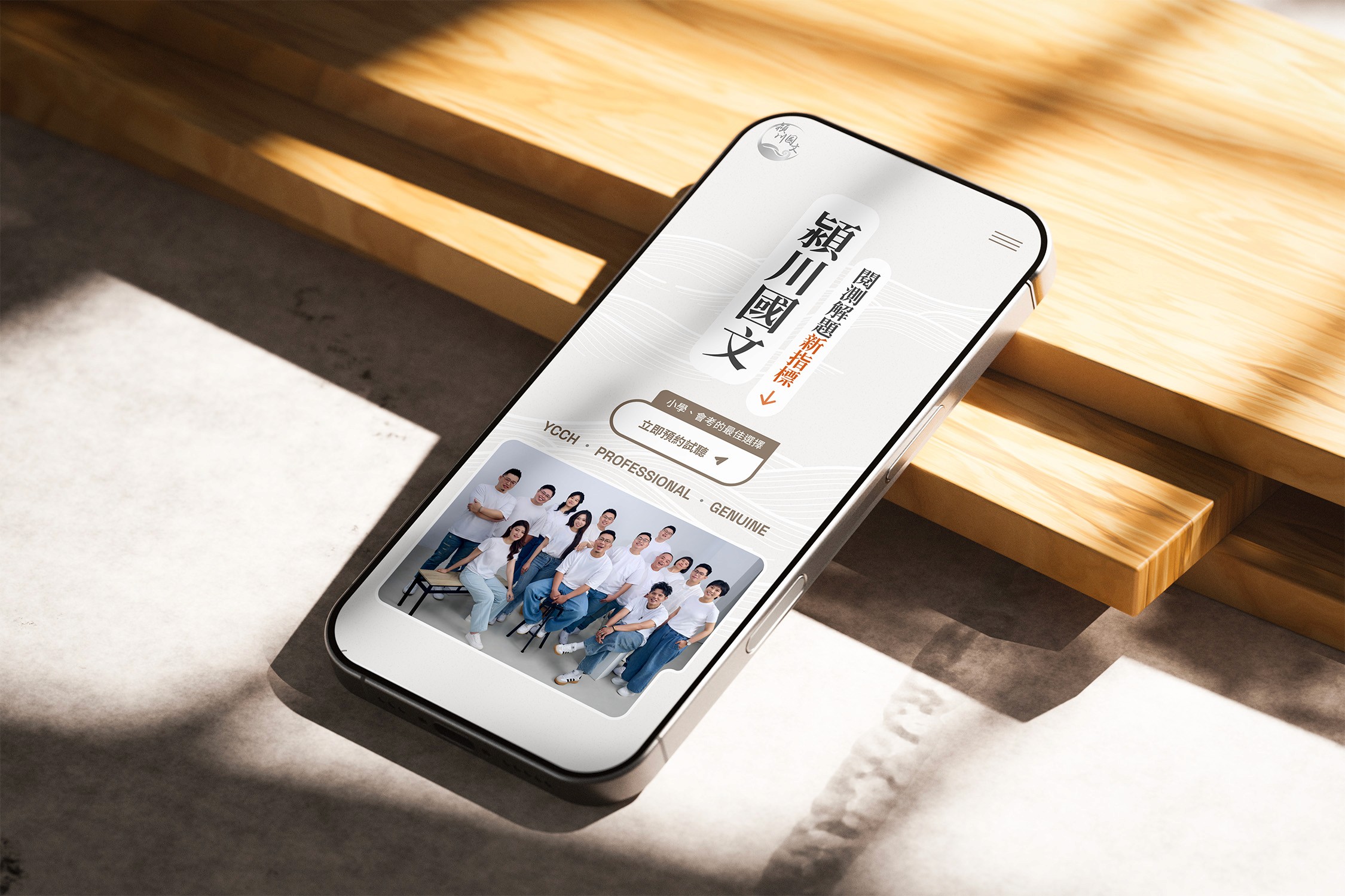 展示潁川國文的手機網頁設計介面，手機在陽光灑落的小台階前。