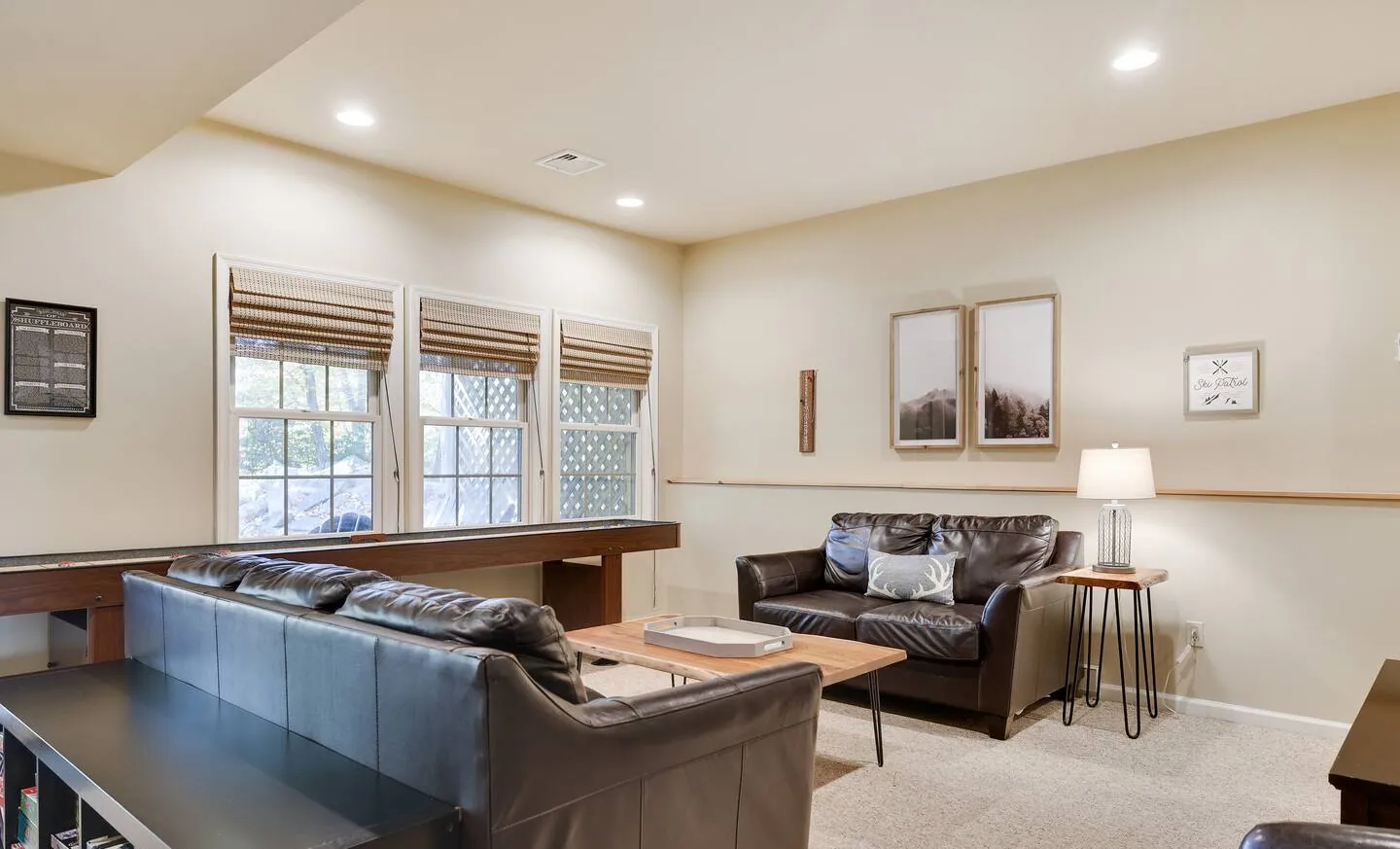 Lower level lounge with leather sofas and windows at Mountainwoods Memories