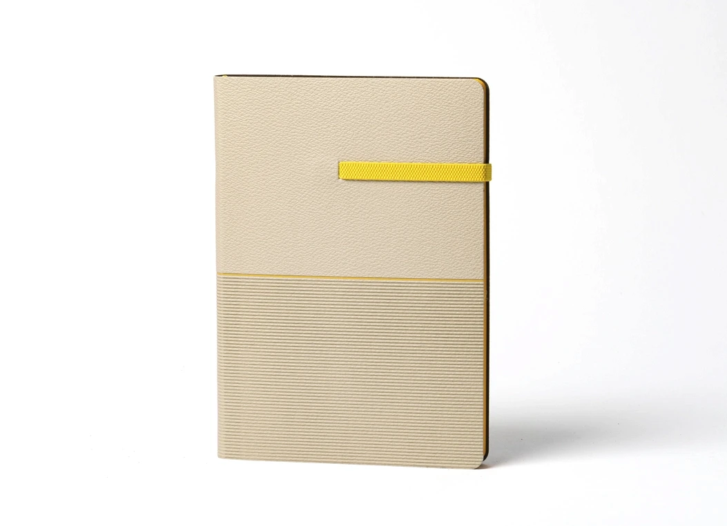 Closed beige journal showing textured lower panel and yellow strap