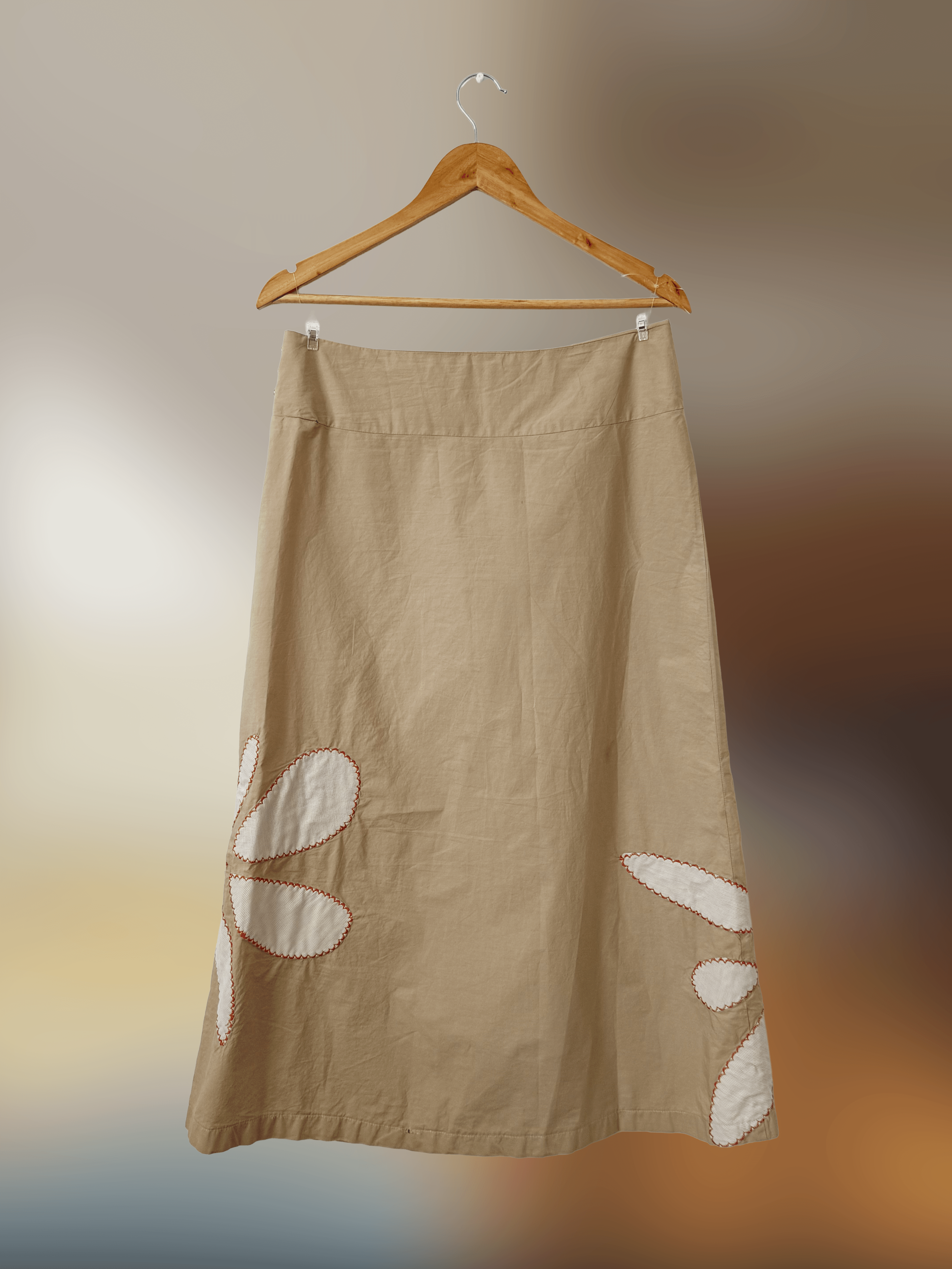 back of beige long skirt with some white flower petal patchwork