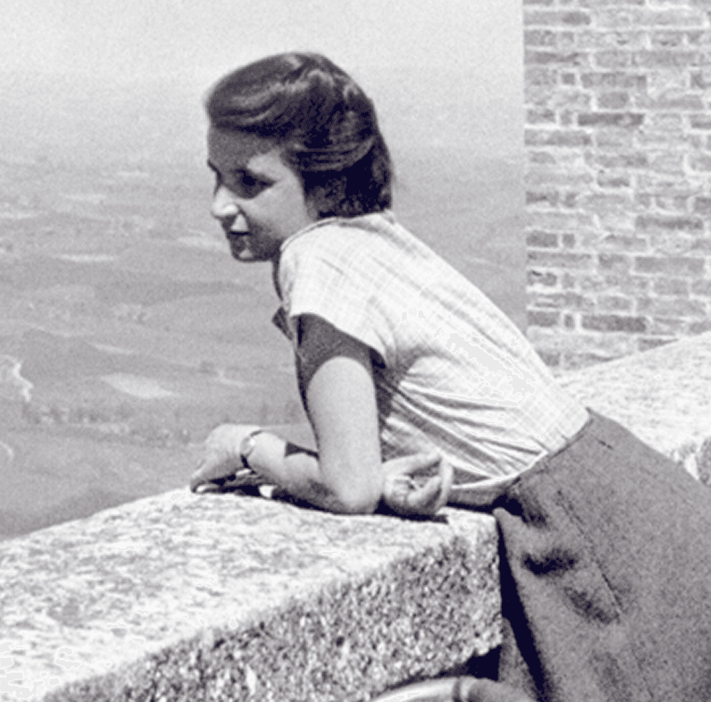 Black-and-white photo of Rosalind Elsie Franklin looking through a microscope.