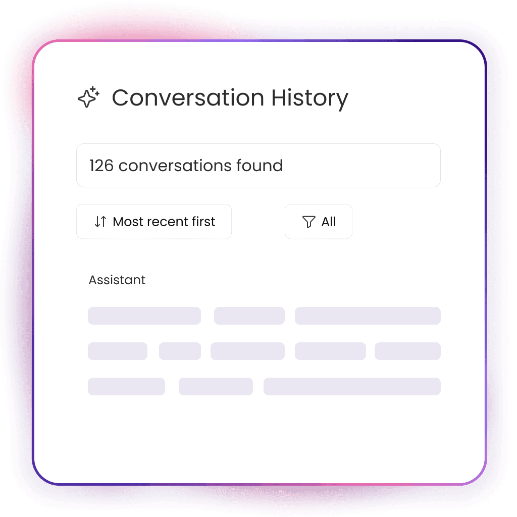 A young person with curly hair smiles at the camera while sitting in front of a laptop against a dark background.