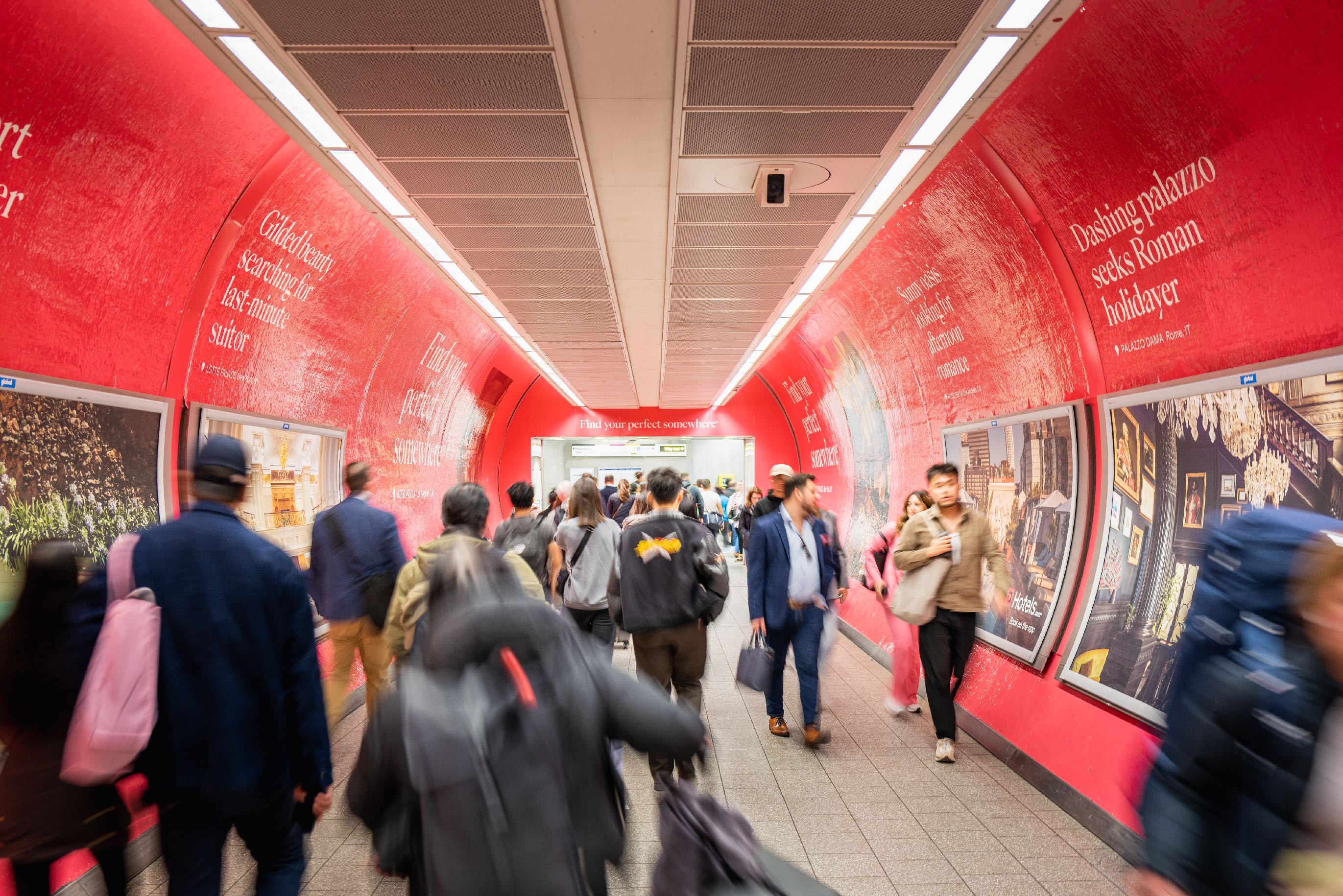 a man walking down a street past a large poster