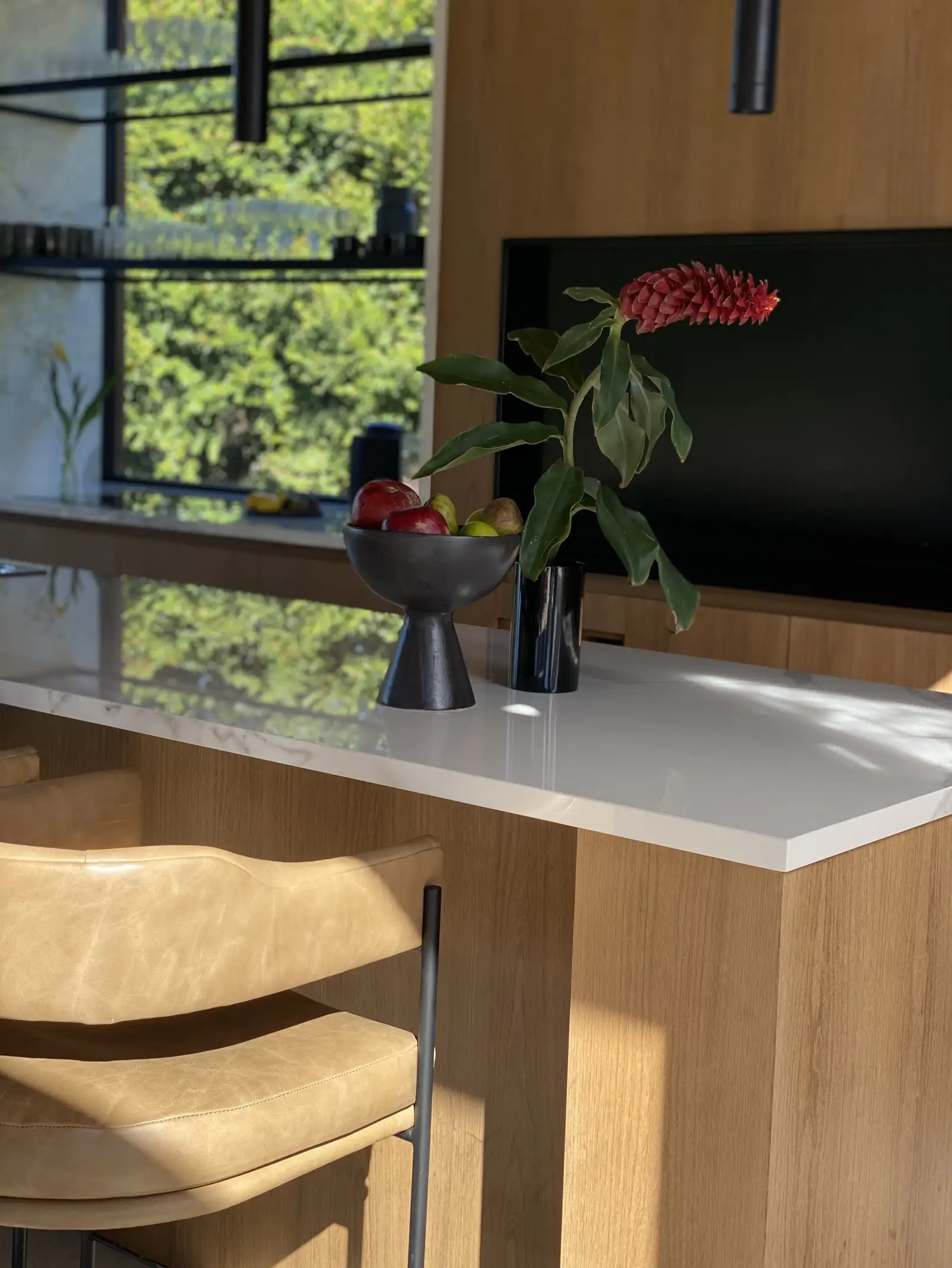 Composición floral tropical con flor roja en cocina moderna para proyectos de interiorismo que integran naturaleza y diseño contemporáneo.