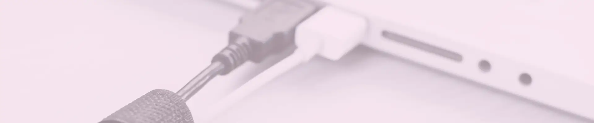 Close-up of charging cables connected to a tablet or laptop, showcasing an organized power setup.