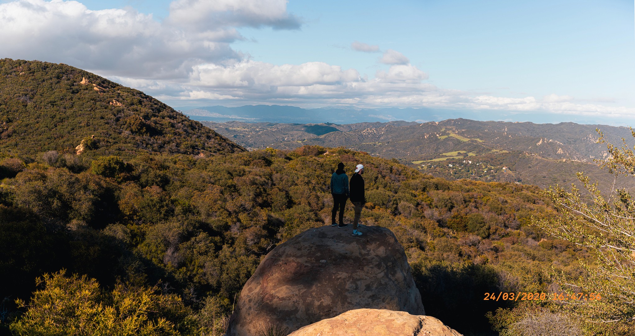  Deux amis admirant la vue sur l'océan depuis une colline à Topanga, en Californie.