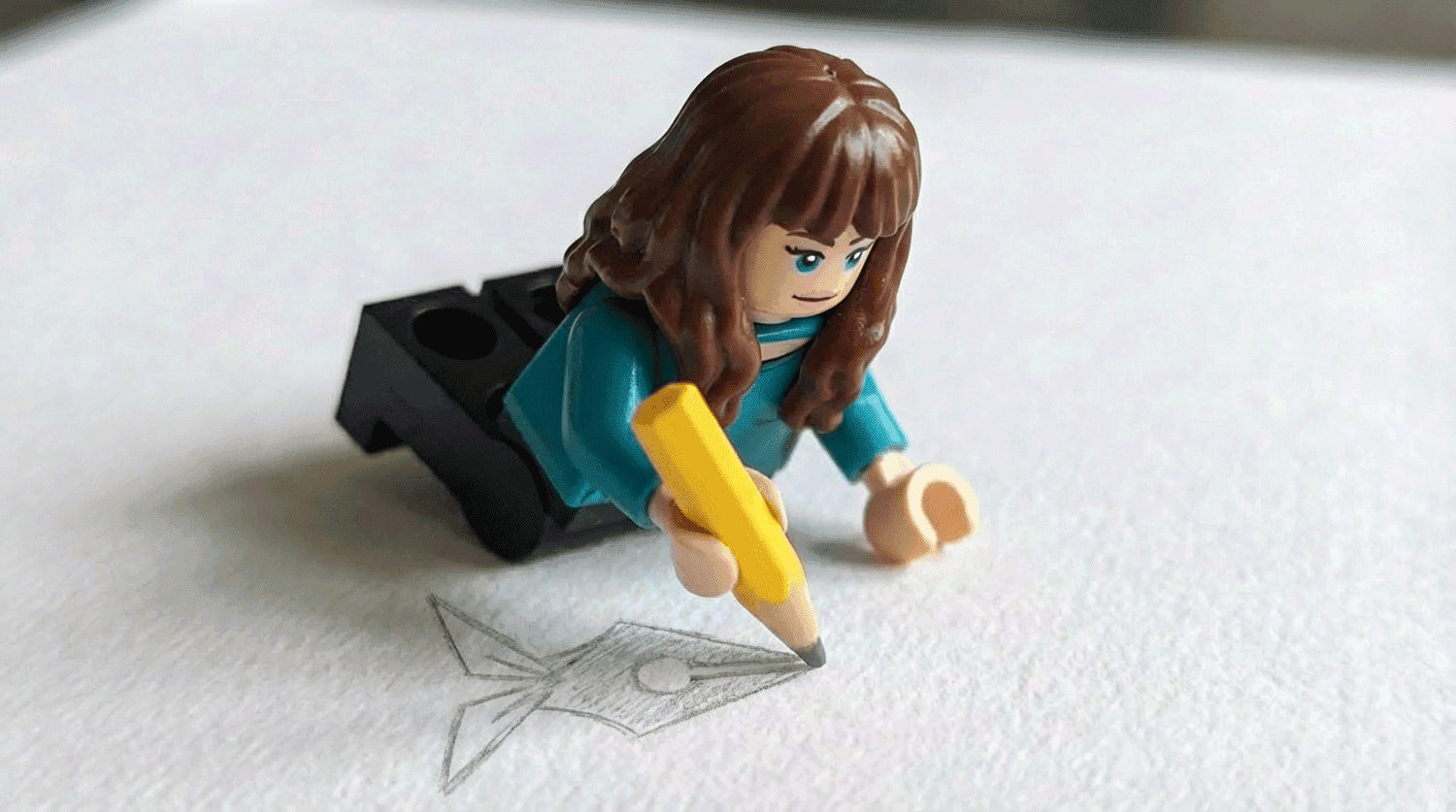 Black and white photo of two people looking at a computer screen with papers on wall