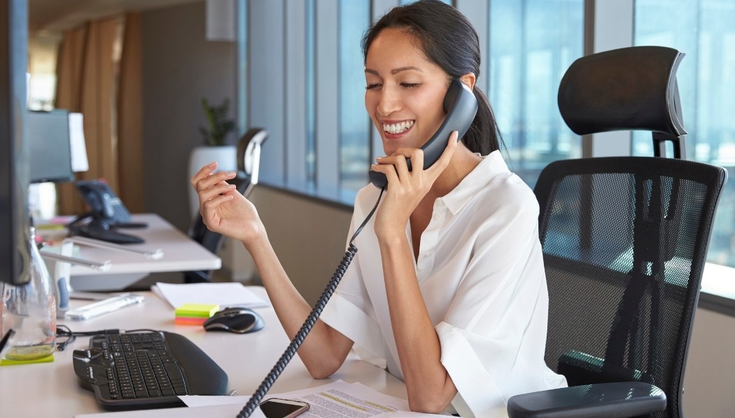 Smiling woman using laptop, representing satisfaction and post-purchase evaluation in the consumer decision-making process.