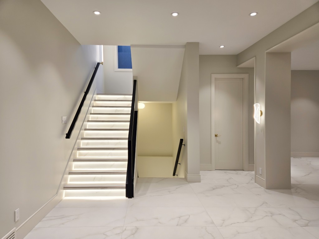 Image of Modern staircase with illuminated steps and sleek design by KHD Homes, showcasing interior design and construction expertise.