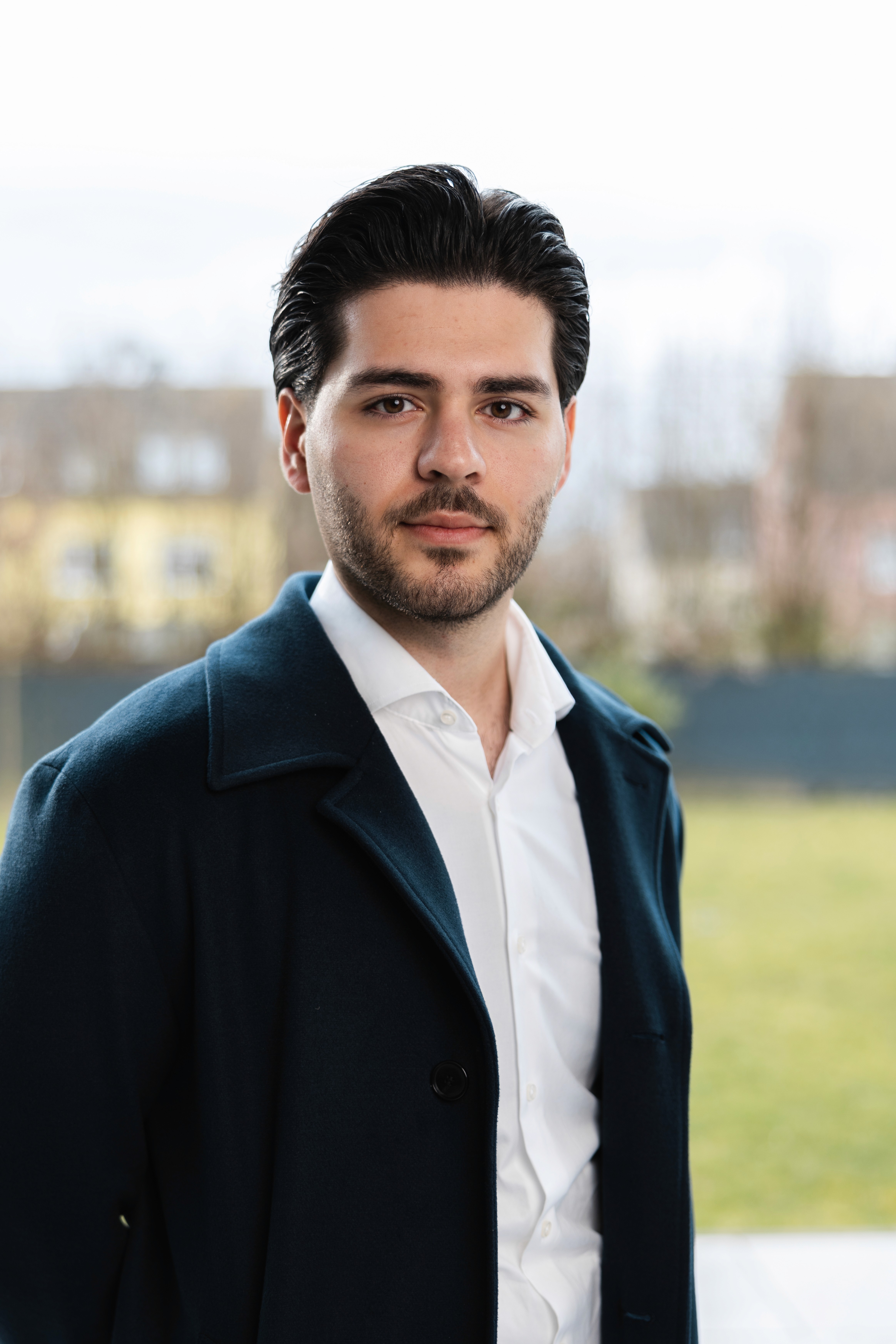 Smiling young Asian woman with long black hair, wearing a brown turtleneck against a neutral gray background. Warm and approachable vibe.