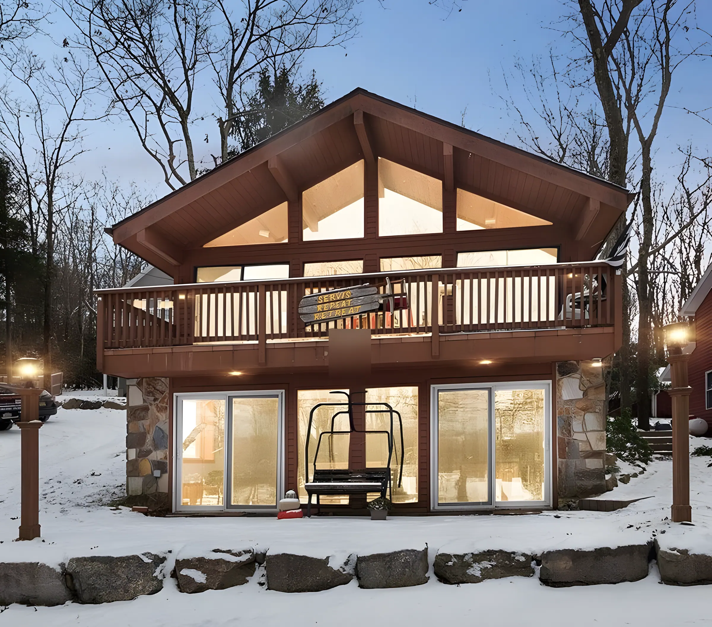 Chalet with wide balcony and ski lift chair bench in winter at Repeat Retreat, Lake Harmony, PA