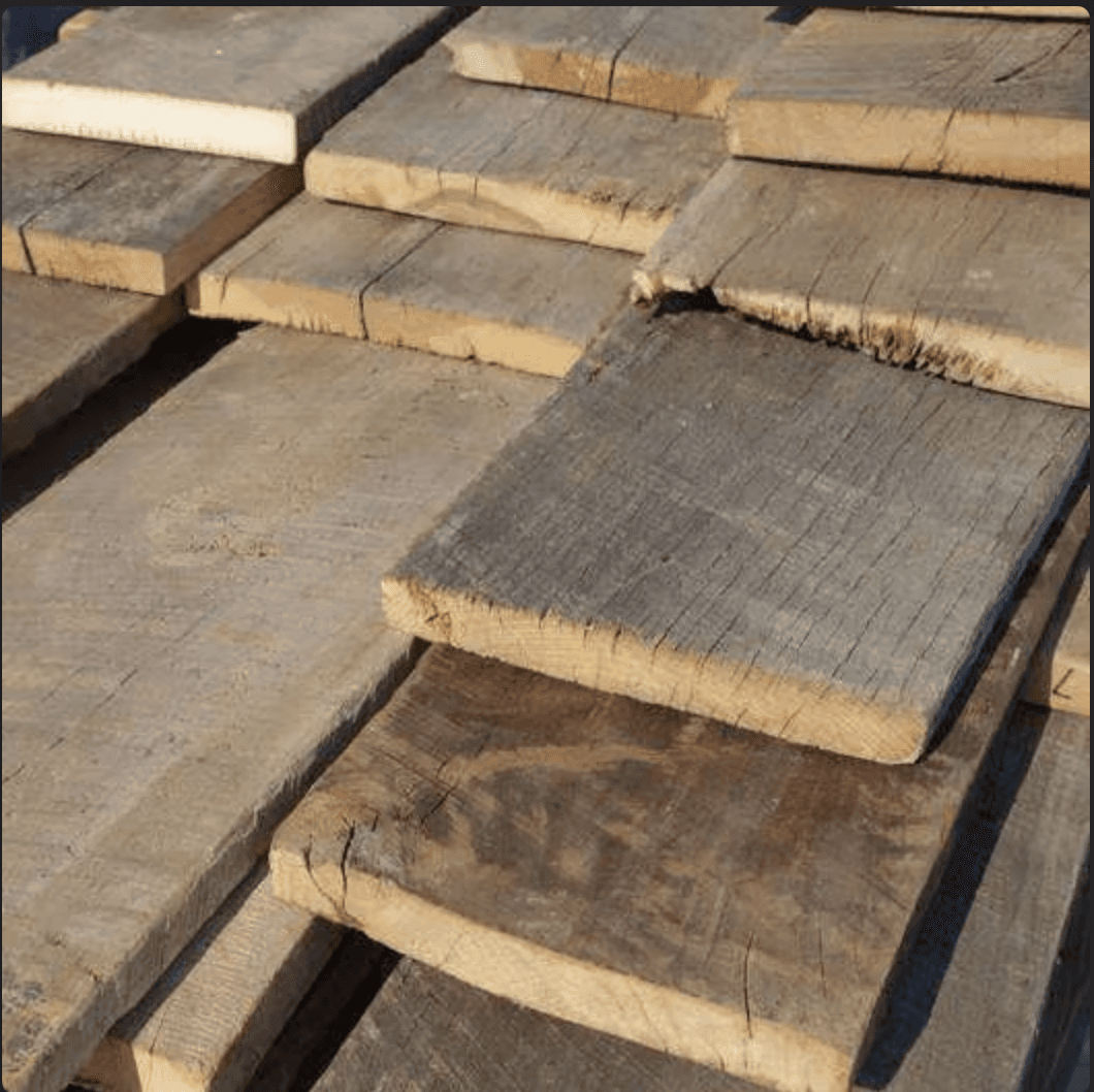 Flat-lay of curated material samples including stone tiles, textured fabrics, ceramics, and botanicals arranged on a neutral surface.