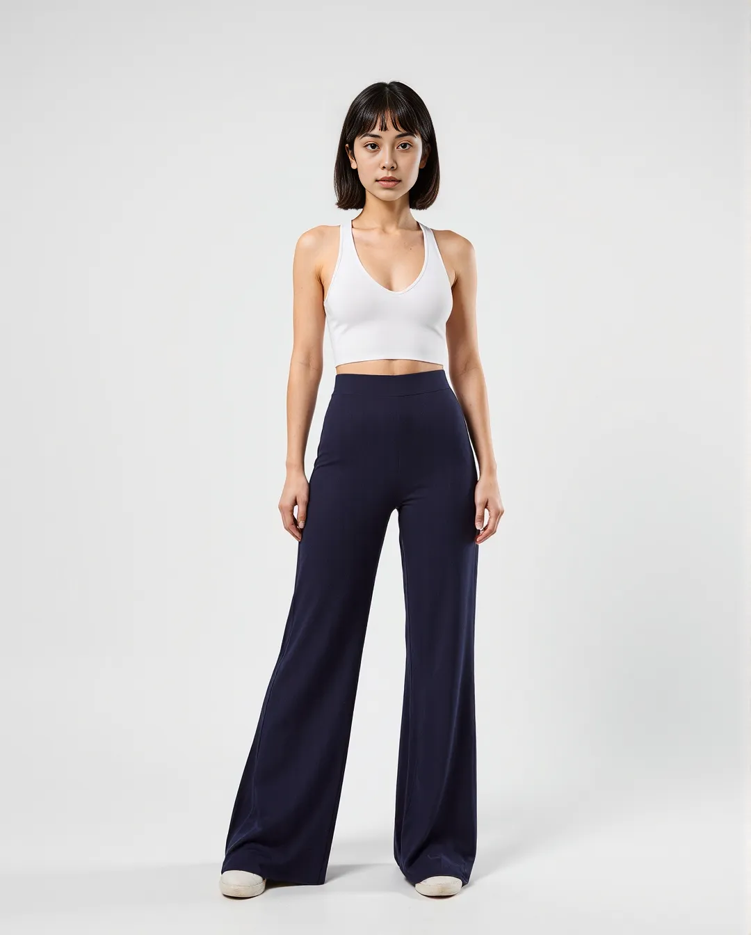 Minimalist fashion styling with white crop top and navy wide-leg pants against neutral background, showcasing clean AI studio photography