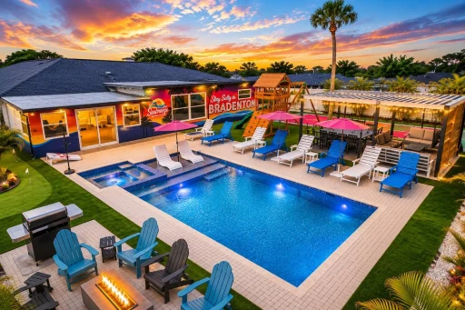Twilight aerial of backyard with pool lit at Salty House, Bradenton, Florida