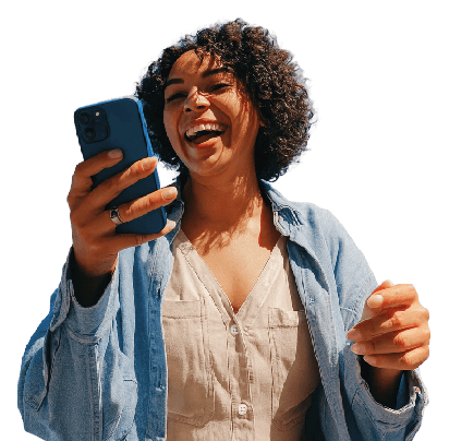 Mujer de tez trigueña sonriendo alegremente mientras sostiene y observa su teléfono móvil.